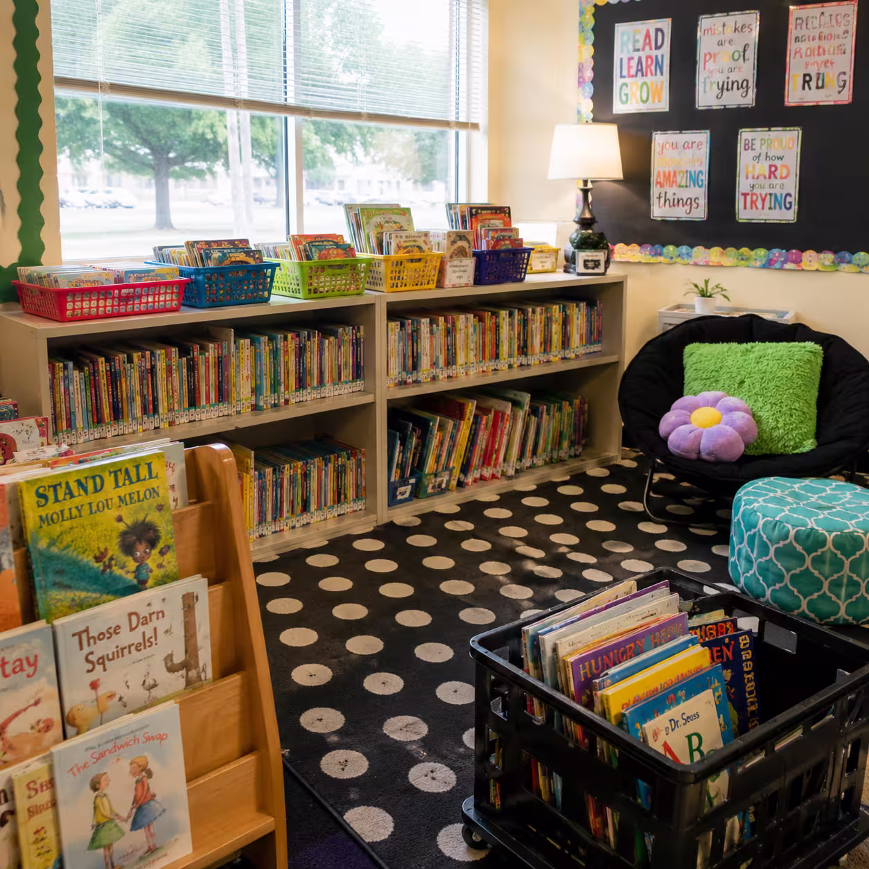 A classroom reading corner with books organized on shelves and in colorful baskets