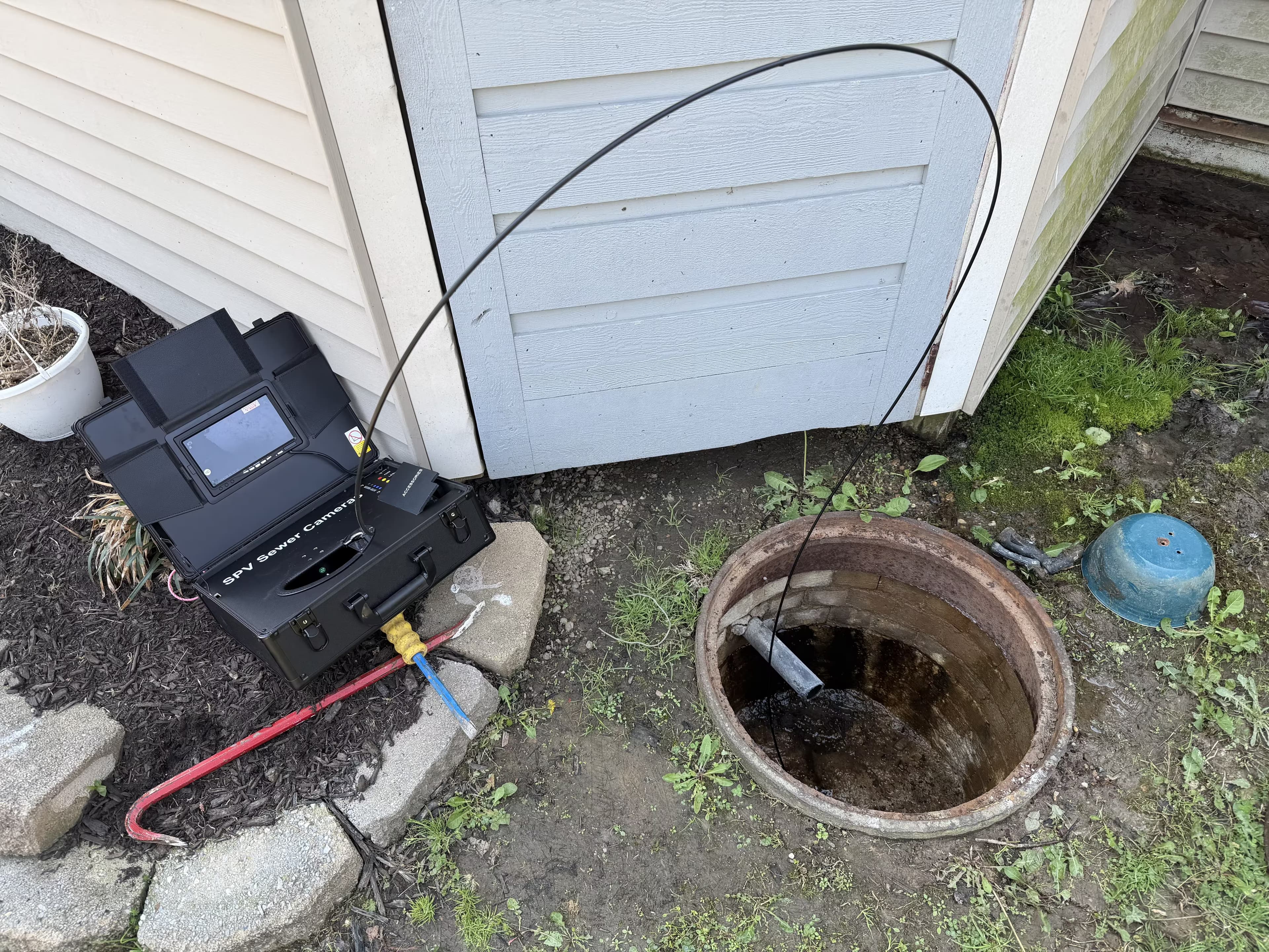 Drain cleaning equipment beside a plumbing cleanout